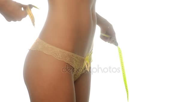 Slim sexual menina no amarelo calcinha medir sua cintura no estúdio — Vídeo de Stock