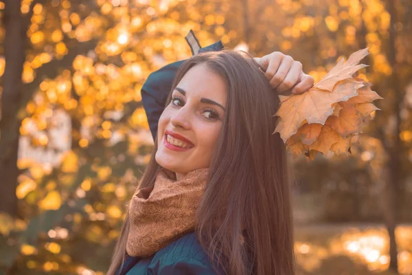 Portret młodej dziewczyny uśmiechniętej jesienią Park z liśćmi w ręku, zbliżenie — Zdjęcie stockowe