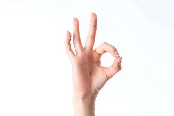 Mano femenina que muestra el gesto de ponerse en contacto con el dedo índice y el pulgar se aísla sobre un fondo blanco — Foto de Stock