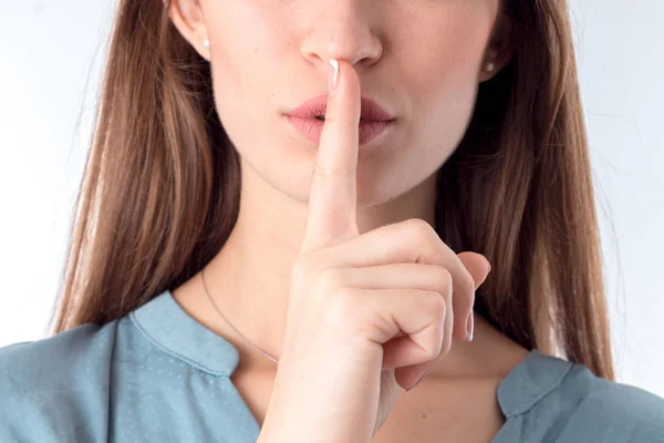 Girl holds  forefinger near the closed mouth closeup — Stock Photo, Image
