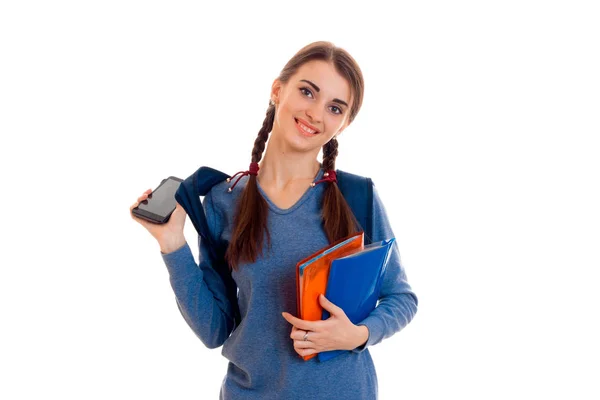 Porträt einer jungen attraktiven Studentin mit Rucksack und Notizbüchern auf weißem Hintergrund — Stockfoto