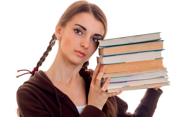 Ritratto ravvicinato di giovane studentessa attraente in abiti sportivi marroni con un sacco di libri in mani isolate su sfondo bianco — Foto Stock