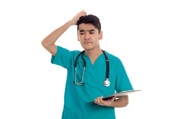 Genç adam doktor stetoskop ve Studio beyaz arka plan üzerinde izole not etmek üniformaya poz — Stok fotoğraf