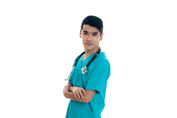 Jeune bel homme médecin posant en uniforme isolé sur fond blanc en studio — Photo