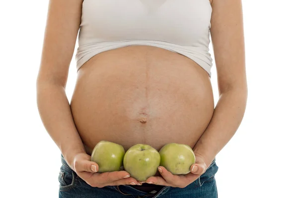 Gravid mamma isolerad på vit bakgrund i studio poserar med gröna äpplen — Stockfoto