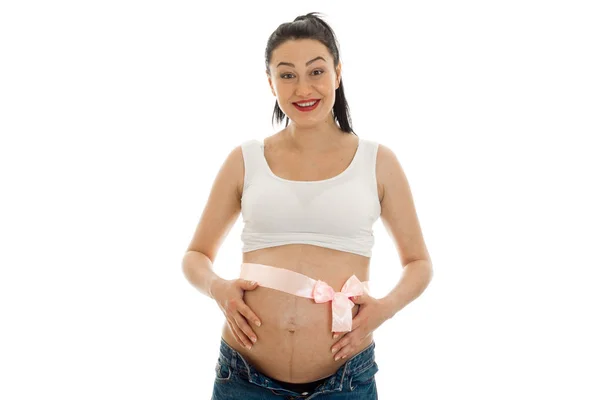 Young cheerful pregnant mother with pink tape on belly isolated on white background in studio posing — Stock Photo, Image