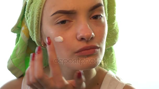 Κορίτσι με μια πετσέτα στο κεφάλι της προκαλεί κρέμα προσώπου — Αρχείο Βίντεο