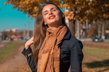 Kahverengi Fularlı güzel kız duran sokak gülümser ve yukarı kaldırdı