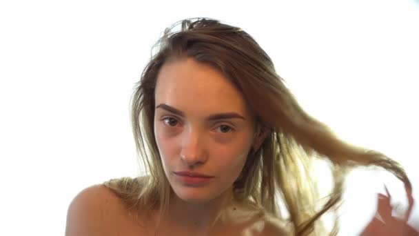 Bela jovem endireita o cabelo e sorri — Vídeo de Stock