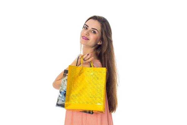 Девушка с длинными волосами тянется вперед желтый пакет из магазина изолированы на белом фоне — стоковое фото
