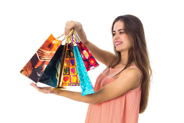 Jovem com cabelos longos fica de lado e subiu na mão dos belos pacotes coloridos close-up — Fotografia de Stock