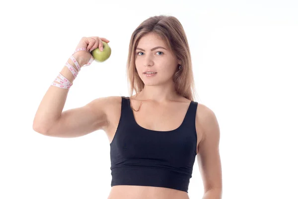 Fille se tient directement et montre une pomme dans une main ses muscles — Photo