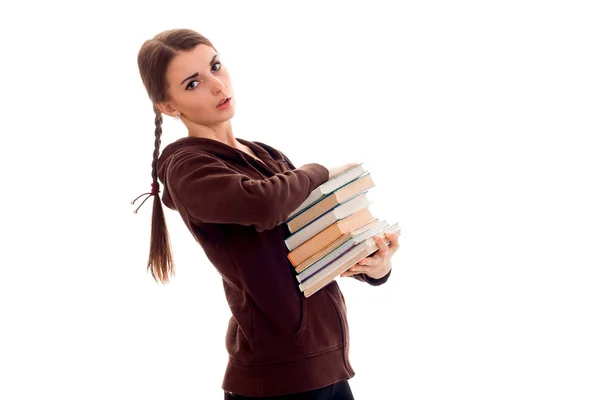 Bella giovane ragazza bruna studente con un sacco di libri in mani isolate su sfondo bianco — Foto Stock