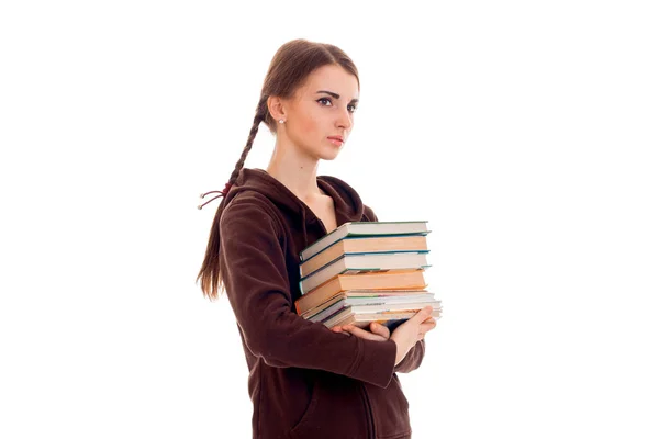 Hübsche junge brünette Studentin mit vielen Büchern in den Händen isoliert auf weißem Hintergrund — Stockfoto