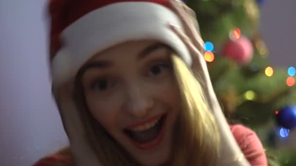 Alegre joven en sombrero de santa sonriendo en la cámara. estado de ánimo de Navidad — Vídeos de Stock