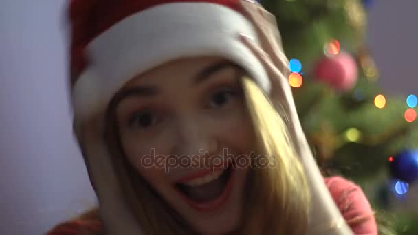 joyeuse jeune fille au chapeau de Père Noël souriant à la caméra. humeur de Noël 