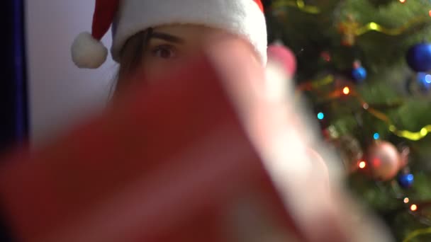 Una encantadora joven en Sombrero Santa recibe regalo de Navidad — Vídeos de Stock