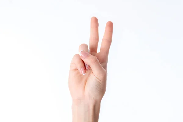 Γυναικείο χέρι δείχνοντας τη χειρονομία με δύο δάχτυλα για αυξημένα μέχρι είναι απομονωμένα σε λευκό φόντο — Φωτογραφία Αρχείου