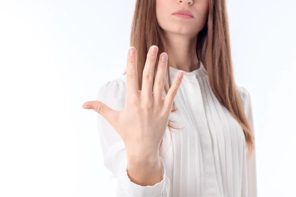 Девушка в белой рубашке держит перед собой руку и показывает пять пальцев на ногах крупным планом — стоковое фото