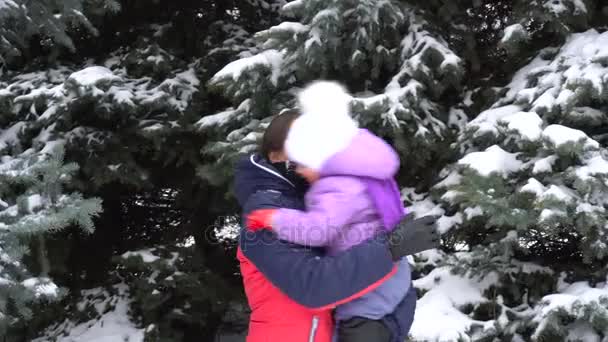 Μητέρα κρατά την κόρη της στην αγκαλιά της και στριφογυρίζει της σε εξωτερικούς χώρους το χειμώνα — Αρχείο Βίντεο