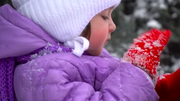 Pretty young girl shakes snow from her clothes outdoors at winter time — Stock Video