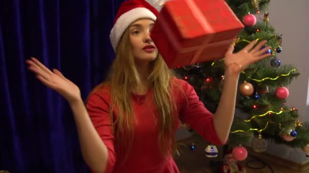 Hermosa chica divirtiéndose con regalo de Navidad y mostrando los pulgares hacia arriba — Vídeos de Stock