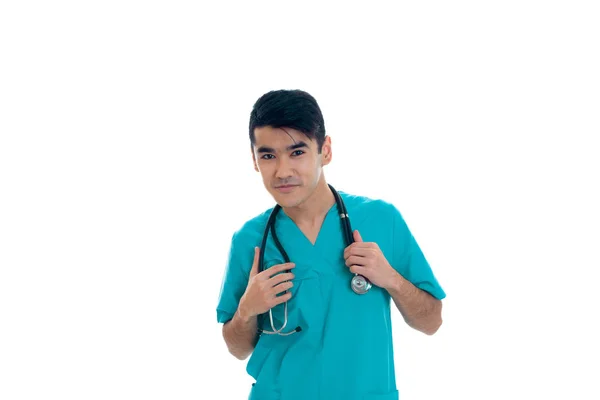 Beau jeune médecin masculin avec stéthoscope en uniforme posant isolé sur fond blanc — Photo