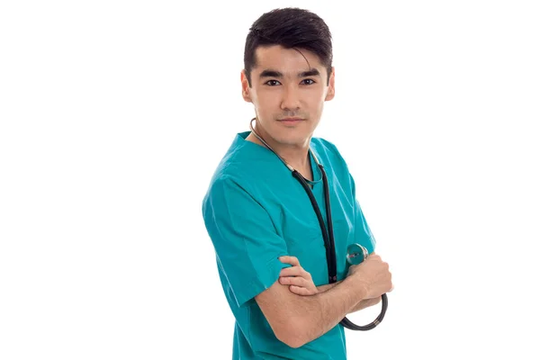 Hermoso joven médico masculino con estetoscopio en uniforme posando aislado sobre fondo blanco —  Fotos de Stock