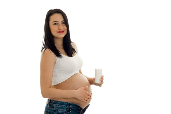 Vacker gravid kvinna poserar med glas mjölk isolerad på vit bakgrund — Stockfoto