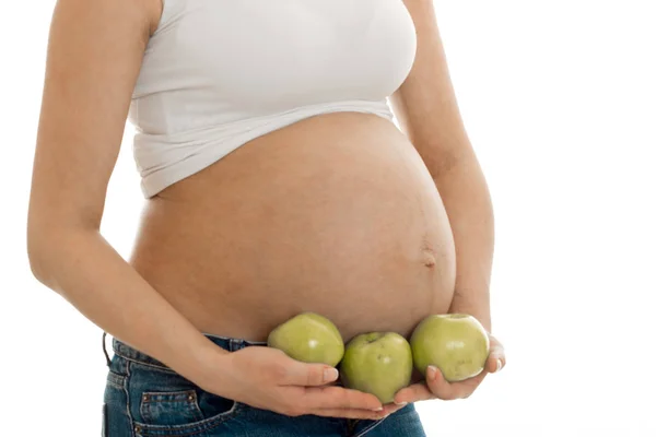 Hamile kadın beyaz arka plan üzerinde izole elinde yeşil elma ile poz — Stok fotoğraf