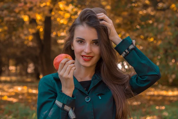 Pin-up menina segura uma maçã em sua mão e melhora o fechamento do cabelo — Fotografia de Stock