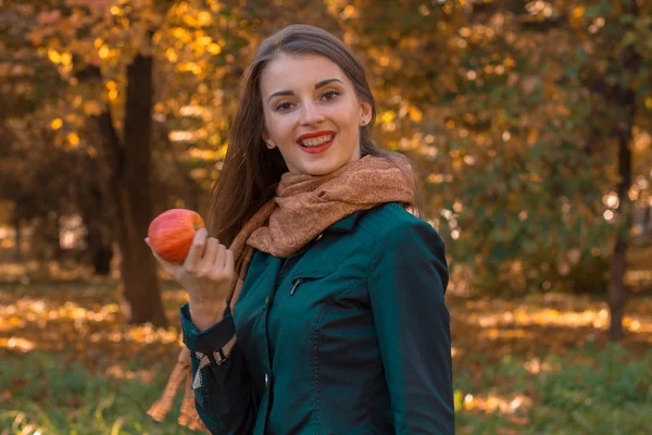 Lycklig flicka i parken håller Apple i hand — Stockfoto