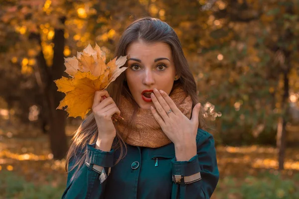 Giovane ragazza chiude la bocca e tiene la mano vicino alla persona bouquet foglie primo piano — Foto Stock