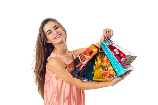 Chica feliz levantado en las manos de paquetes de colores con regalos y sonriendo aislado sobre fondo blanco —  Fotos de Stock