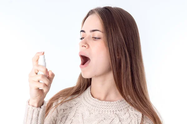 Joven chica chorros garganta curativo spray aislado en blanco fondo — Foto de Stock