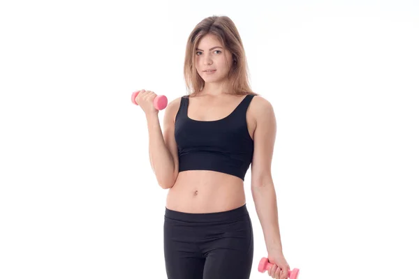 Sports girl looking forward bending one arm holding a dumbbell — Stock Photo, Image