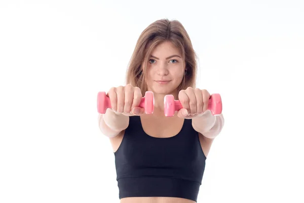 Jong meisje in een zwarte sport top bedrijf halters — Stockfoto