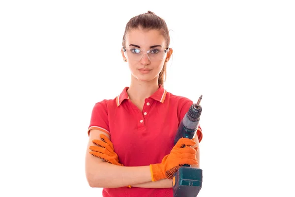 Retrato de joven hermosa chica constructora morena hace renovación con taladro en las manos aisladas sobre fondo blanco — Foto de Stock