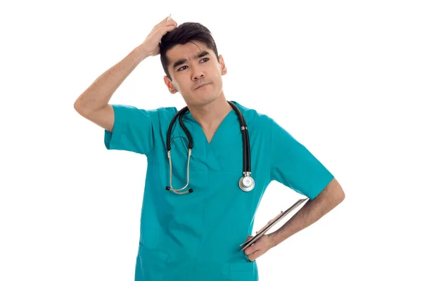 Premuroso giovane medico maschio in uniforme con stathoscope posa isolato su sfondo bianco — Foto Stock