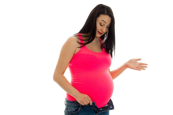 Hermosa embarazada morena con gran vientre posando en camisa rosa aislado sobre fondo blanco — Foto de Stock