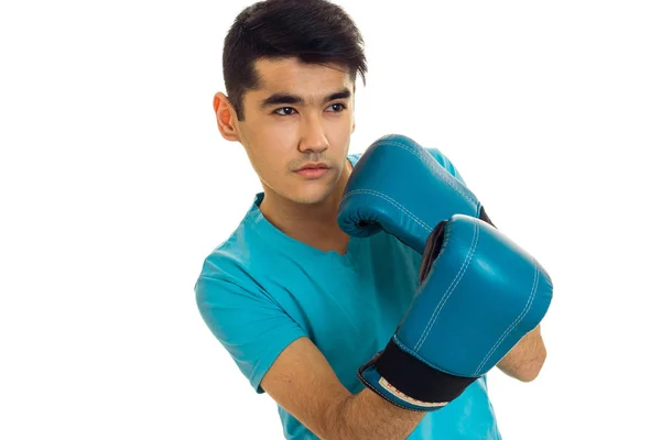 Retrato de jovem homem forte em camisa azul praticando boxe em luvas isoladas em fundo branco — Fotografia de Stock