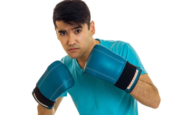 Unge koncentrerad mannen i blå skjorta tränar boxning handskar isolerad på vit bakgrund — Stockfoto