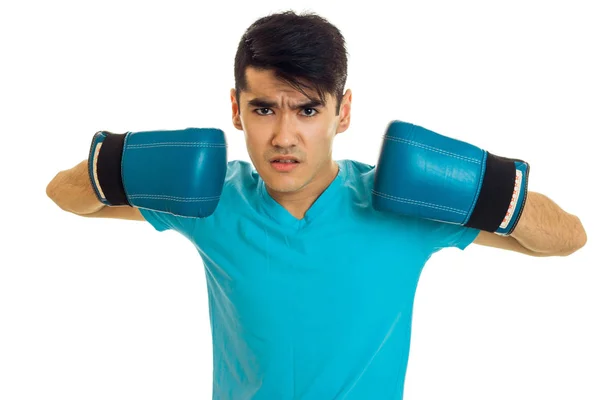 Junger wütender Mann im blauen Hemd übt Boxen in Handschuhen isoliert auf weißem Hintergrund — Stockfoto