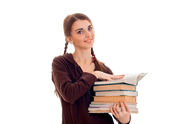 Cheerful young student girl with books in brown sport clothes looking at the camera and smiling isolated on white background. student years concept. study concept. Stock Picture