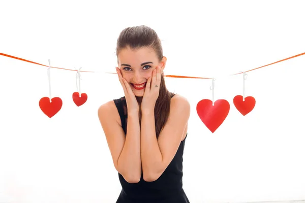 Felice giovane donna con labbra rosse che celebrano il giorno di San Valentino con cuori isolati su sfondo bianco — Foto Stock