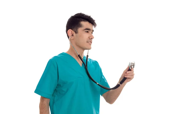 Médico masculino grave em uniforme com estetoscópio posando isolado em fundo branco — Fotografia de Stock