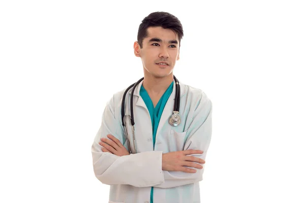 Guapo doctor masculino en uniforme con estetoscopio posando aislado sobre fondo blanco — Foto de Stock