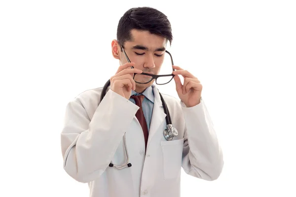 Médico masculino em uniforme e óculos com estetoscópio posando isolado em fundo branco — Fotografia de Stock