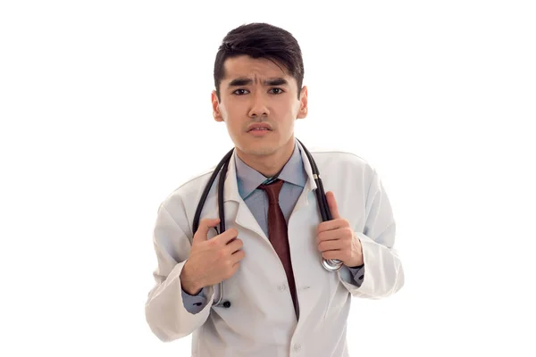 Jovem médico masculino em uniforme com estetoscópio olhando para a câmera isolada em fundo branco — Fotografia de Stock