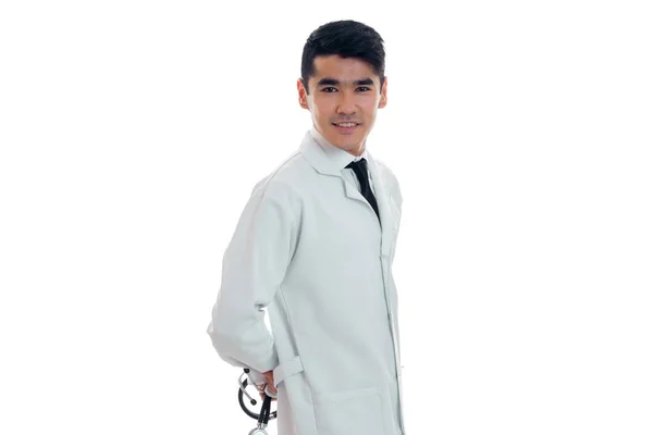 Jovem médico masculino de uniforme branco com estetoscópio olhando para a câmera isolada em estúdio — Fotografia de Stock